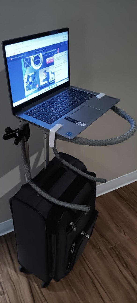 Prod-UP-tivity holding a laptop at working height, clipped to a rolling suitcase
