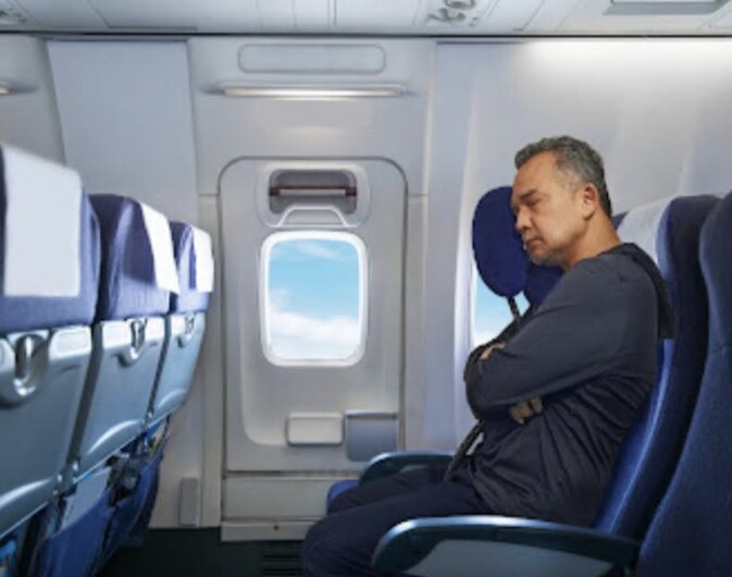 A traveler napping upright in an airplane seat using Prod-UP-tivity